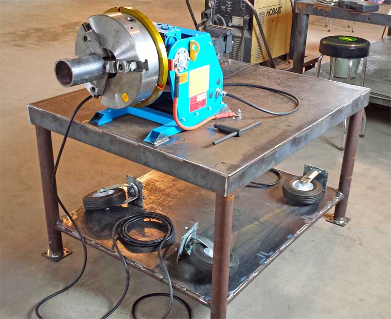 A welding machine is sitting on a table with wheels