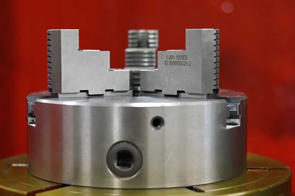 A close up of a metal chuck on a machine.