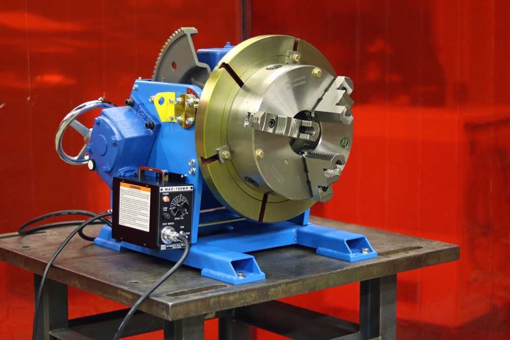 A machine is sitting on a table in front of a red curtain.