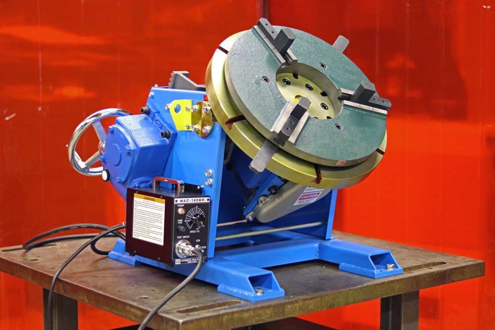 A machine is sitting on a table in front of a red curtain.