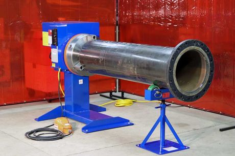 A large pipe is sitting on a machine in a room.