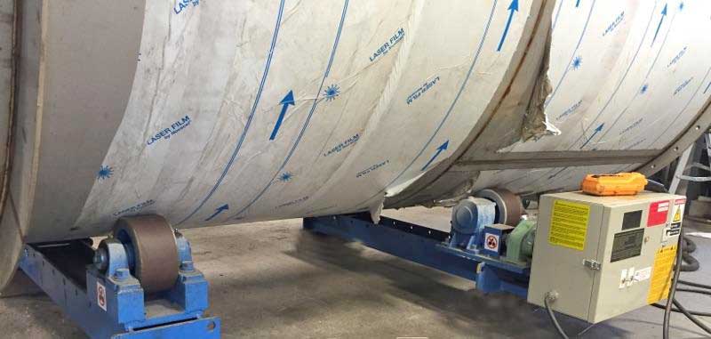 A large metal pipe is sitting on top of a machine.