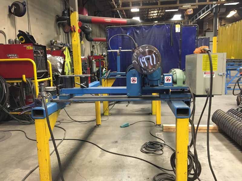 A welding machine is sitting on a table in a workshop.