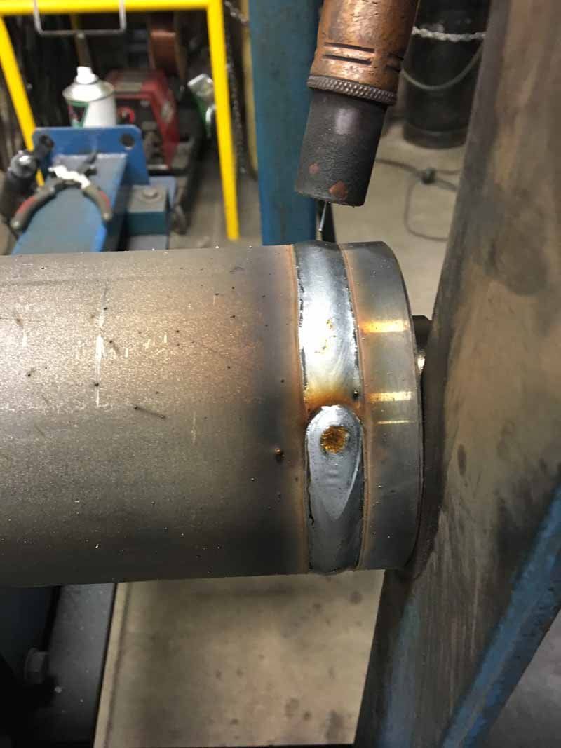 A close up of a welding machine on a metal pipe.