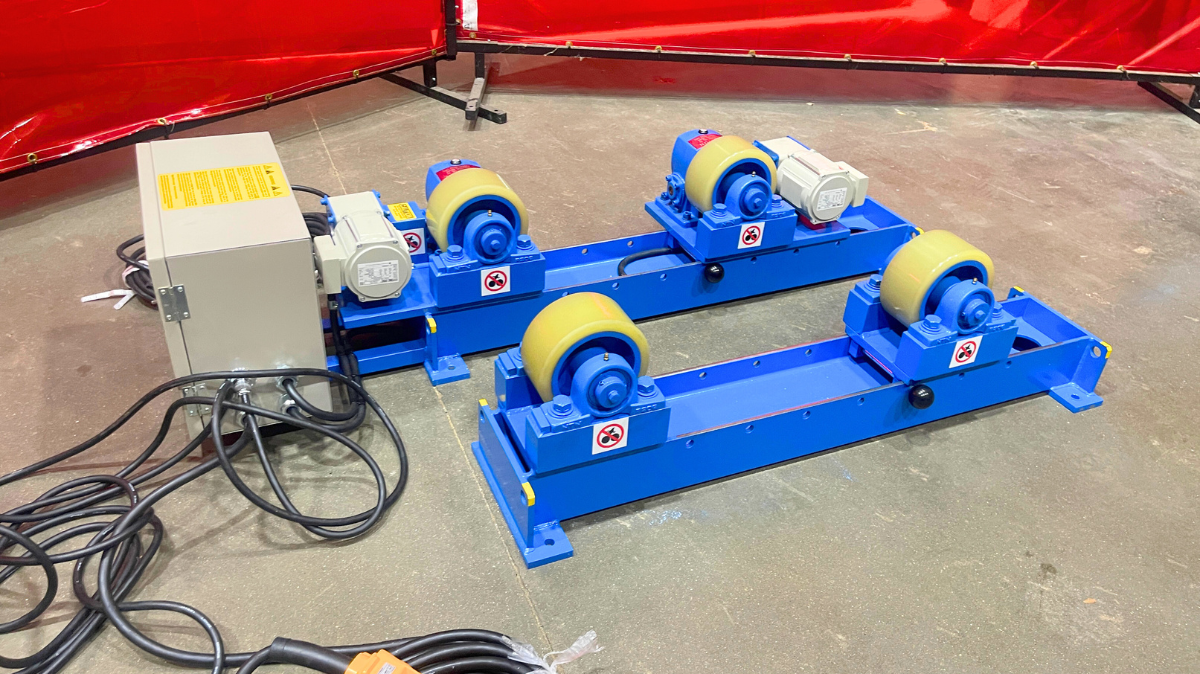 RD-3-INW Tank Turning Roll A blue machine with wheels and a yellow remote control is sitting on a concrete floor.