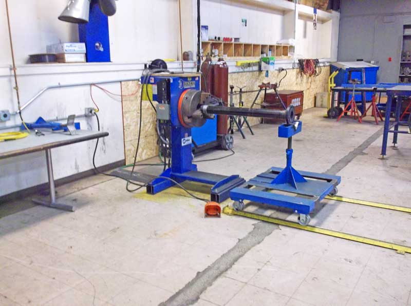 A blue machine is sitting on a table in a workshop