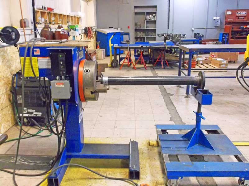 A blue machine is sitting in a room with other machines