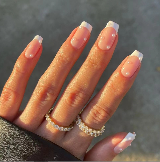 A close up of a woman 's nails with rings on her fingers