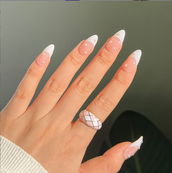 A close up of a woman 's hand with a plaid ring