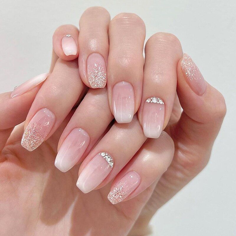 A close up of a woman 's nails with rhinestones on them