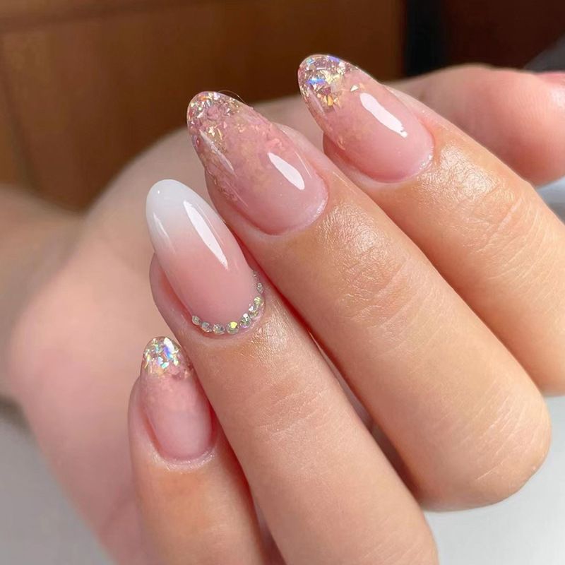 A close up of a woman 's nails with rhinestones on them.