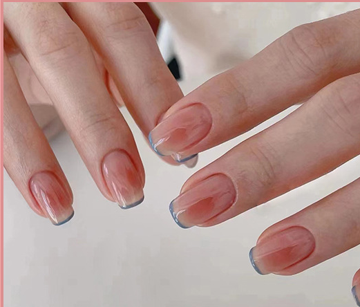 A close up of a woman 's nails with a french manicure