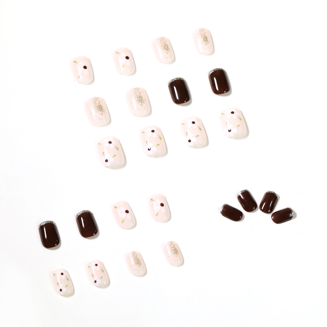 A close up of a woman 's nails with a brown and white design.