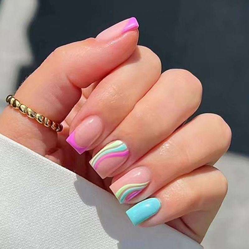 A close up of a woman 's nails with a ring on her finger.