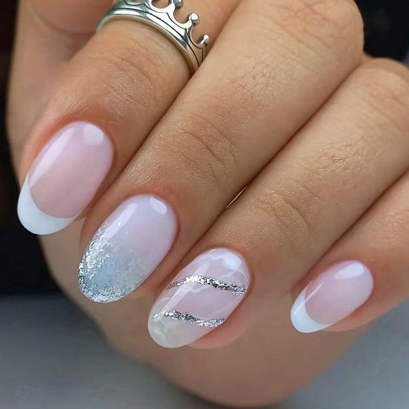 A close up of a woman 's nails with a ring on her finger