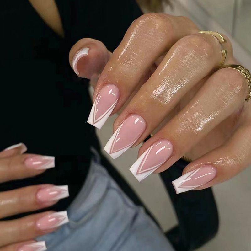 A close up of a woman 's nails with a white french manicure.