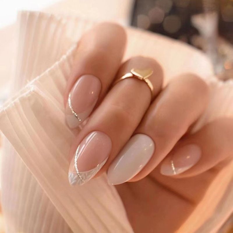 A close up of a woman 's nails with a gold ring