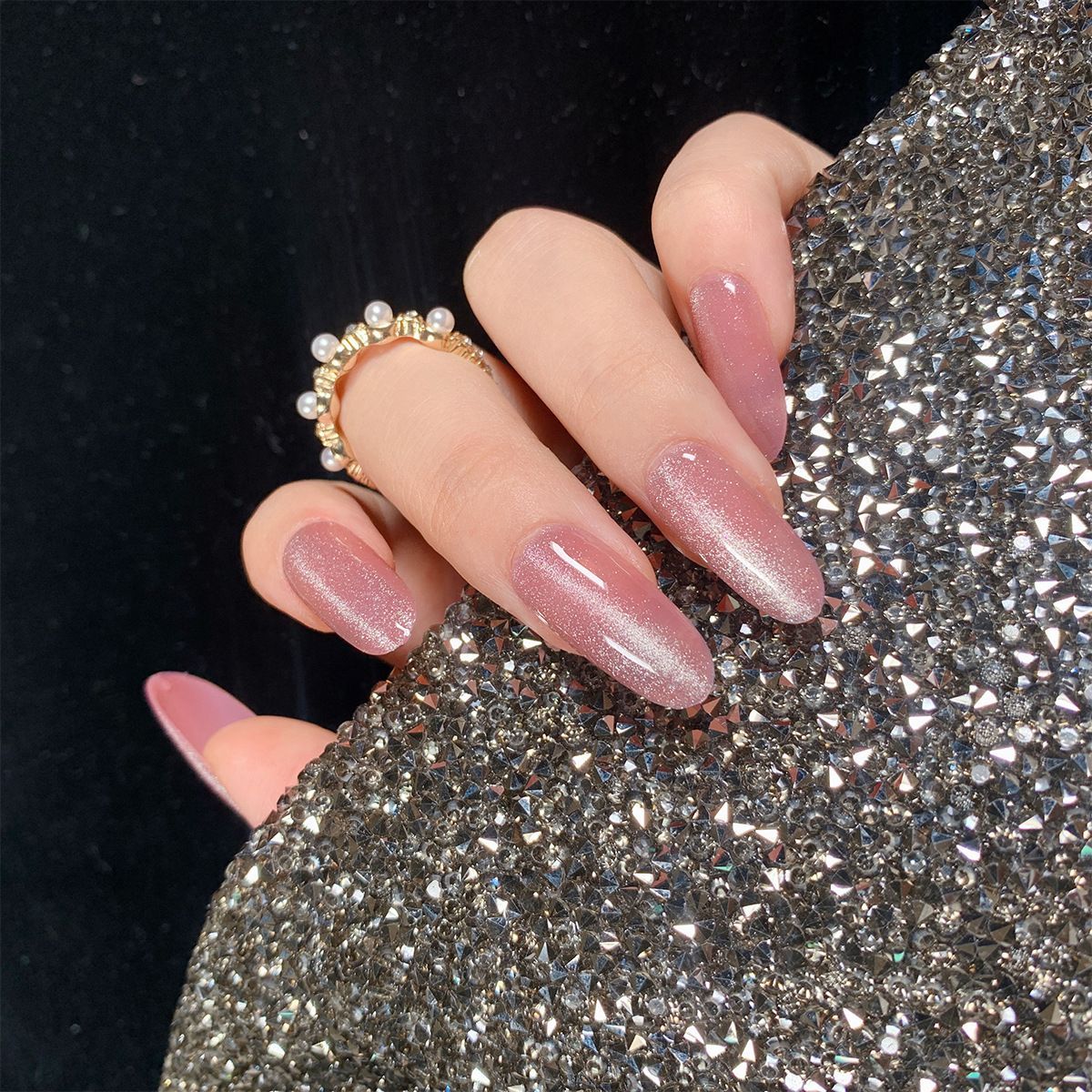 A close up of a woman 's nails with a ring on her finger.