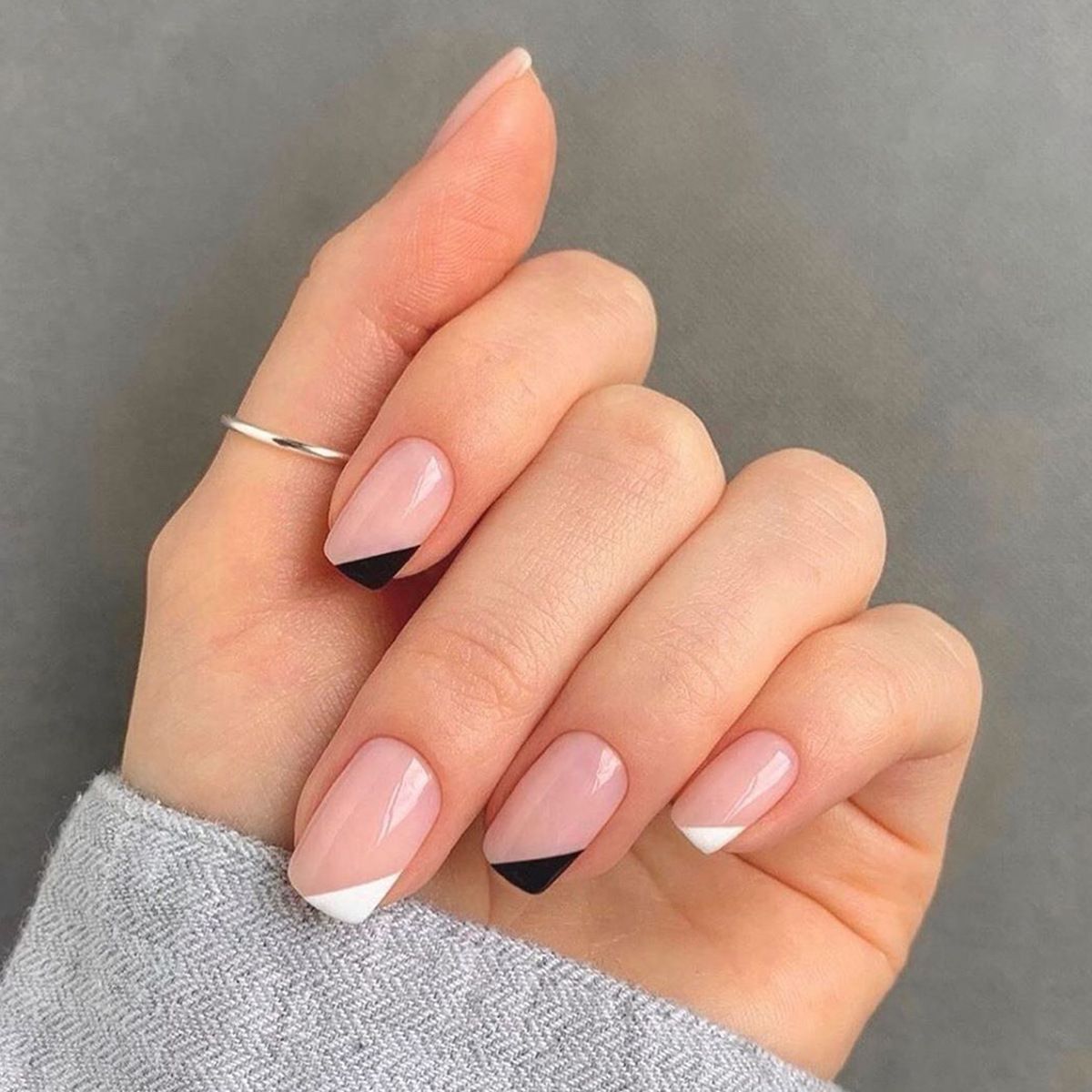 A close up of a woman 's nails with a ring on her finger