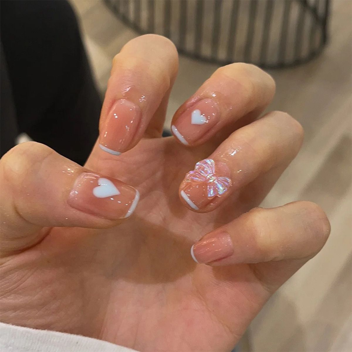 A close up of a person 's nails with a bow on them.