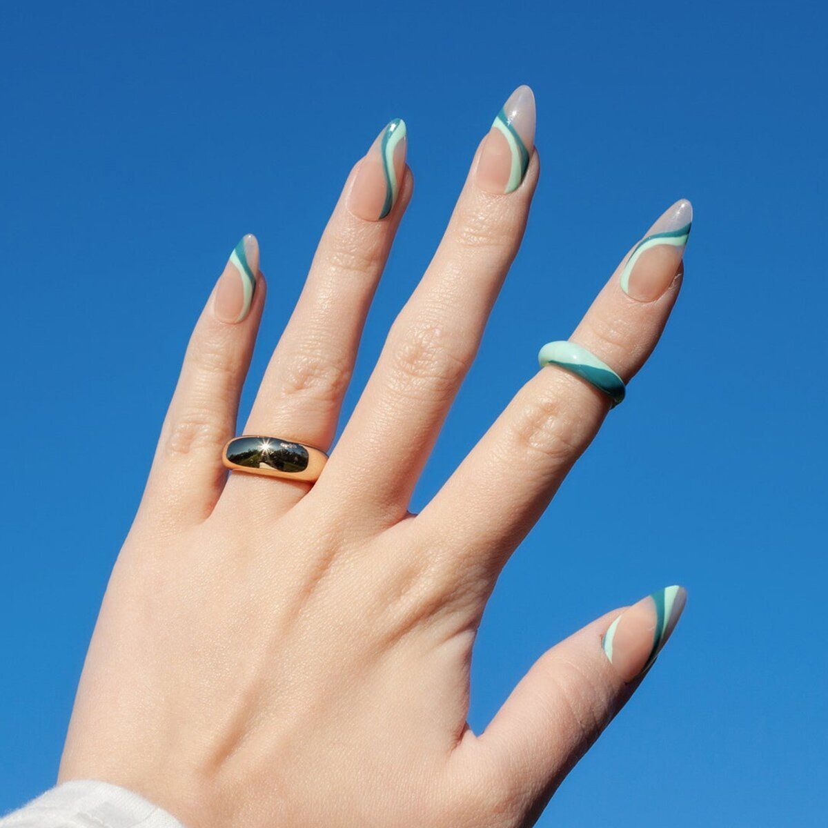 A woman 's hand with a gold ring on her left hand