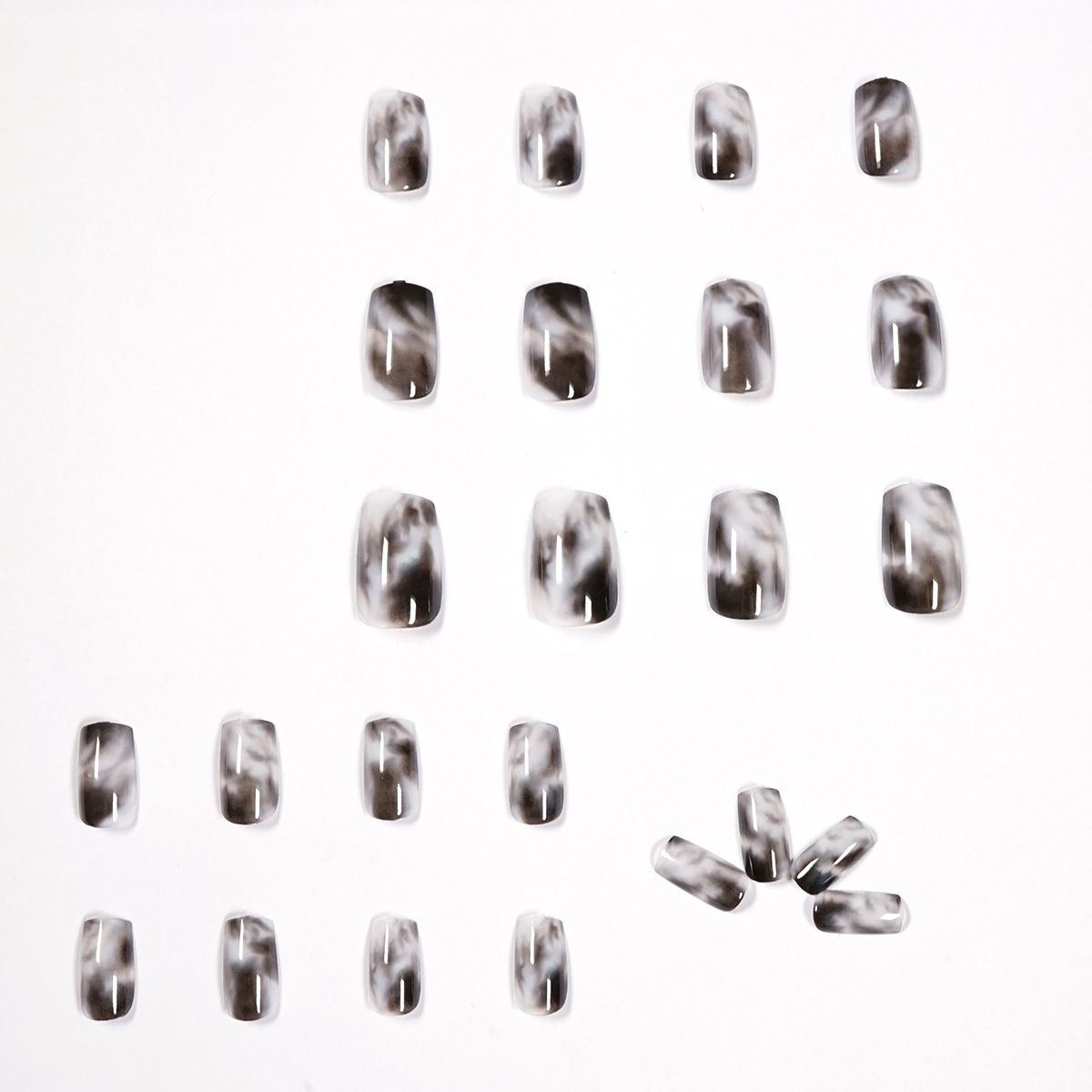 A woman with long black nails is holding a white phone