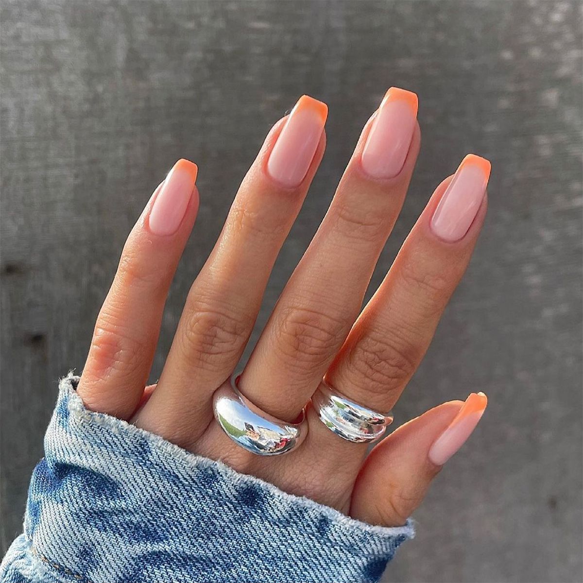 A close up of a person 's hand with two rings on it.