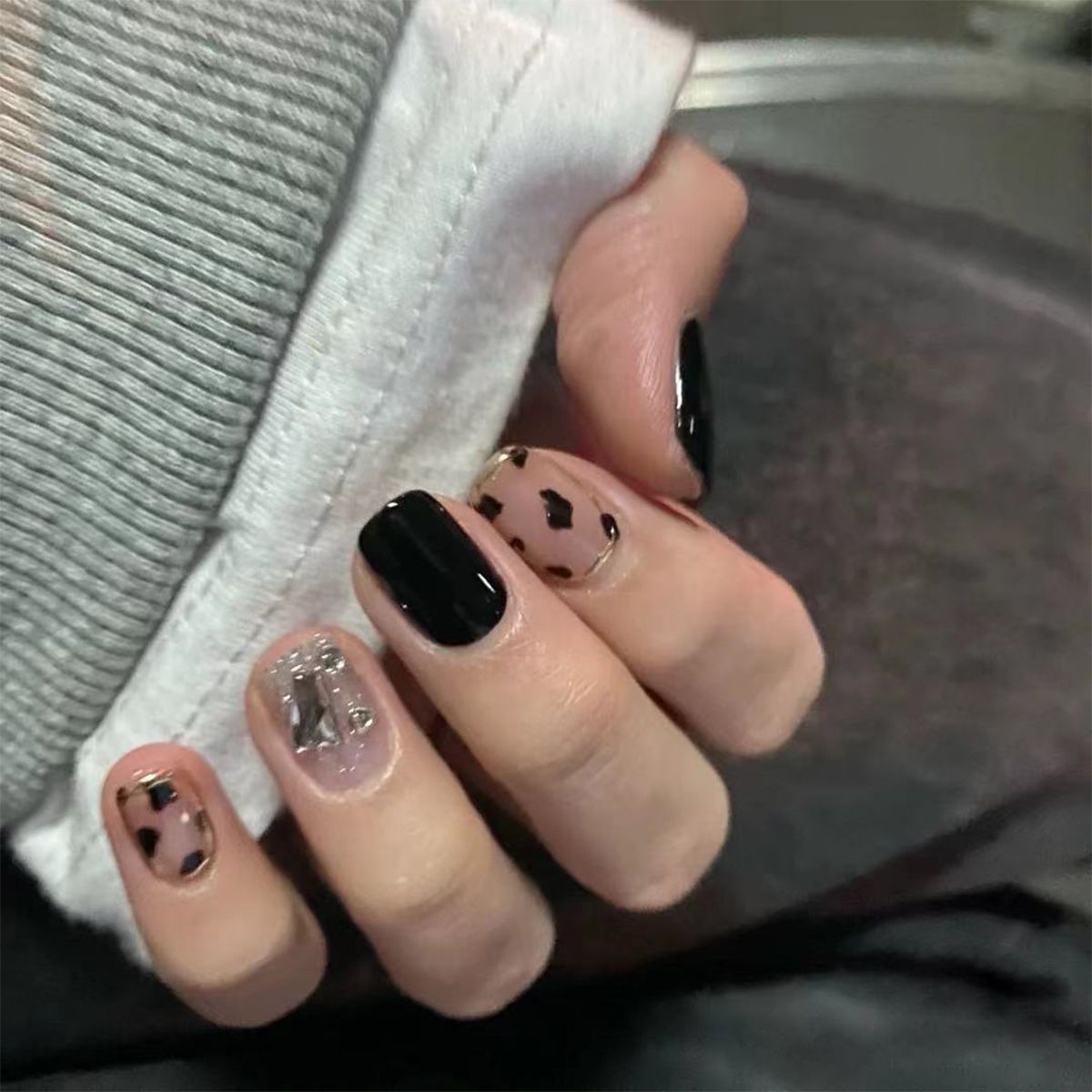 A close up of a person 's nails with a leopard print design.