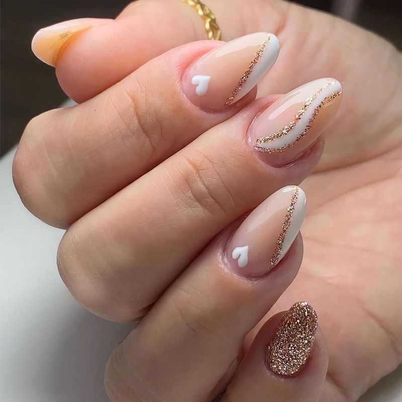 A close up of a woman 's nails with a heart design
