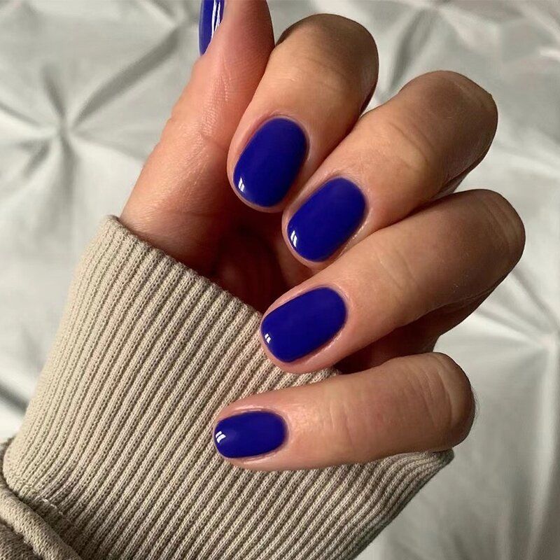A close up of a person 's hand with blue nails