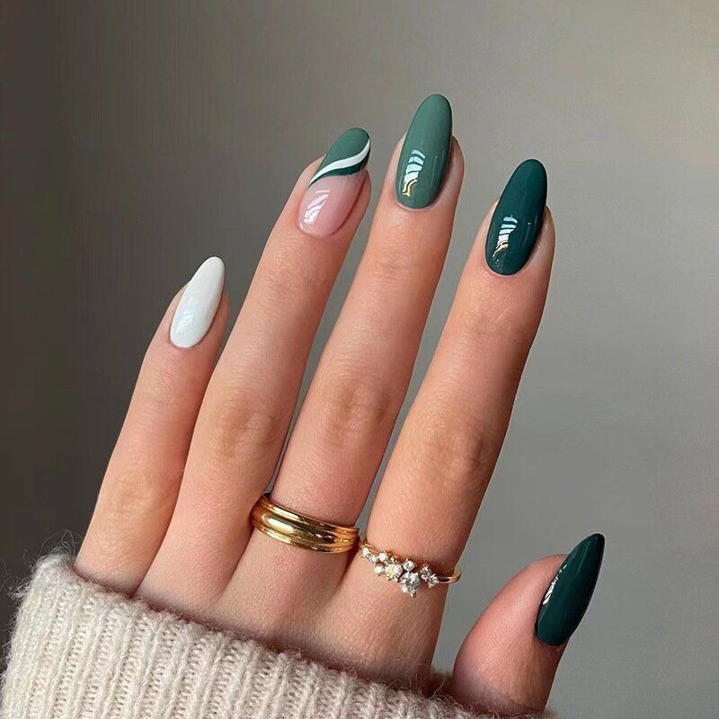 A close up of a woman 's nails with rings on them.