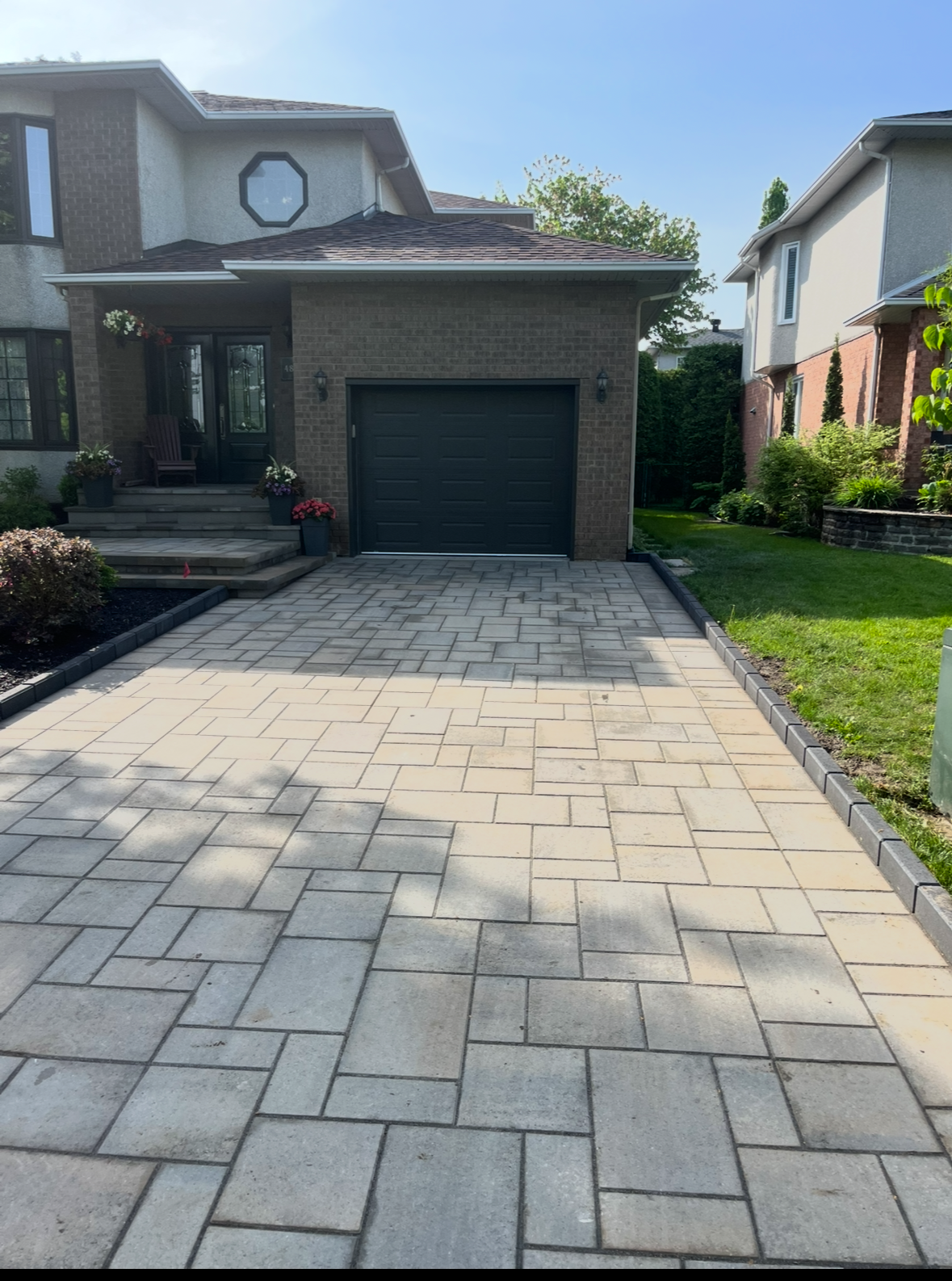 Une allée menant à une maison avec une porte de garage.
