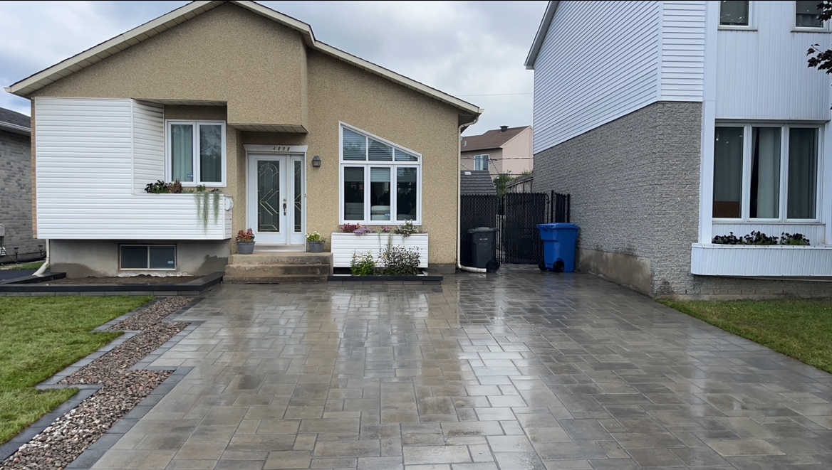 Une maison avec une allée en béton devant elle.