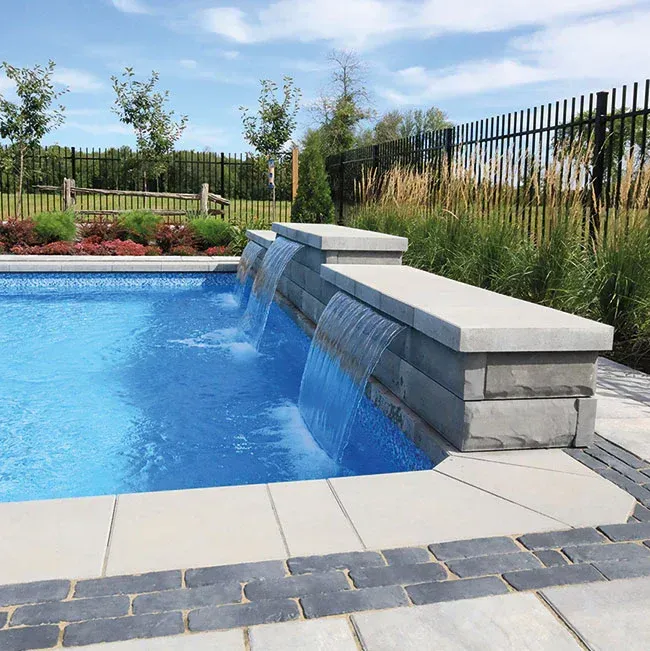 Une piscine avec une cascade au milieu