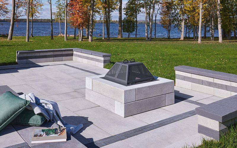 Un foyer est installé au sommet d'une terrasse à côté d'un lac.