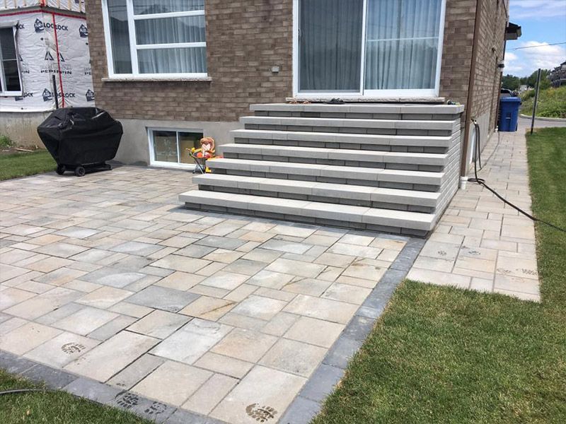 Un patio avec des escaliers menant à l'arrière d'une maison.