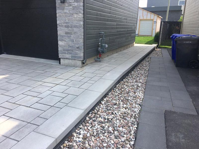 Une allée en briques avec du gravier le long du côté