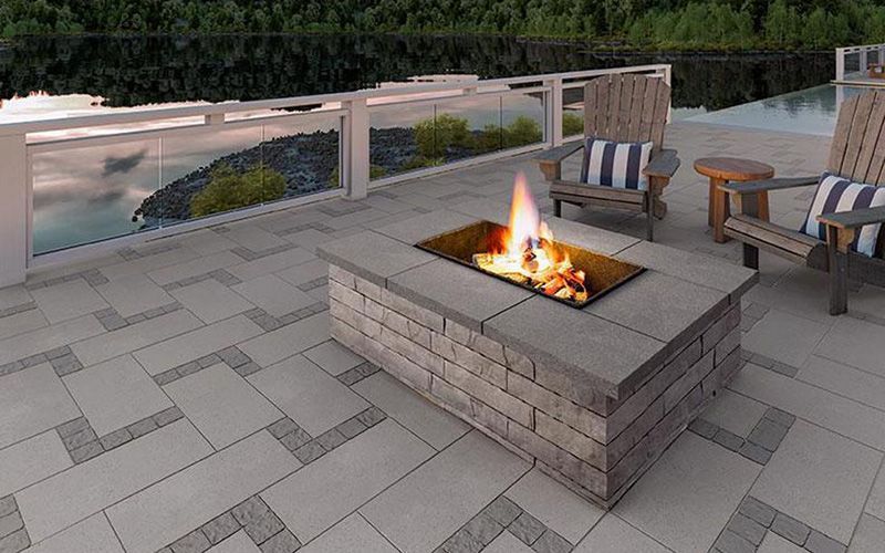 Un foyer est installé au sommet d'un patio à côté de chaises.