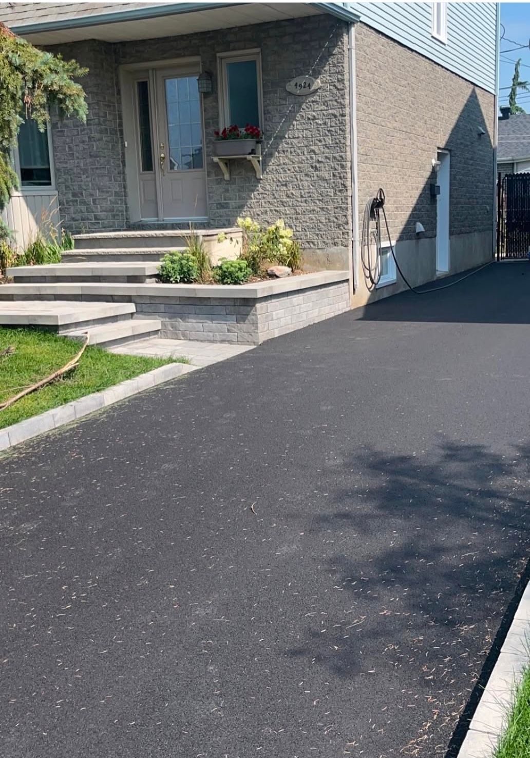 Une maison avec une allée menant à la porte d'entrée et des escaliers.