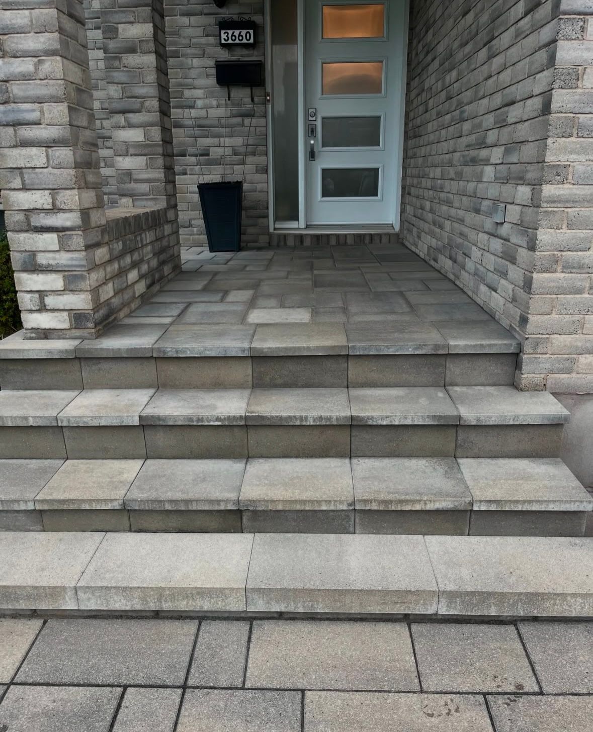 Une maison en briques avec une porte bleue et des marches