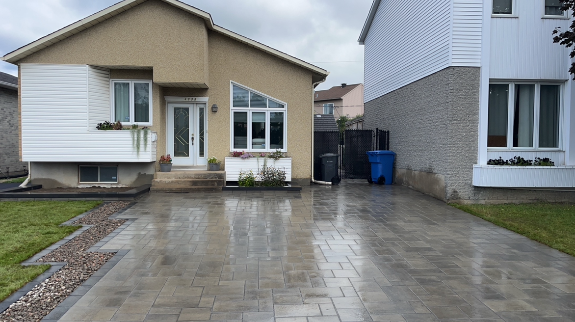 Une maison avec une allée en béton devant elle.