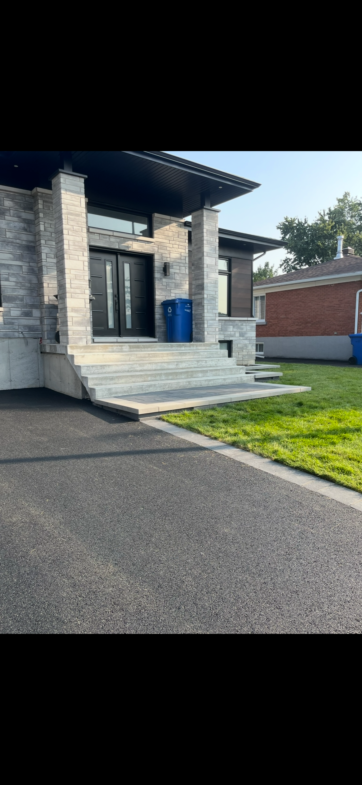 Une allée menant à une maison avec un bâtiment en briques en arrière-plan.