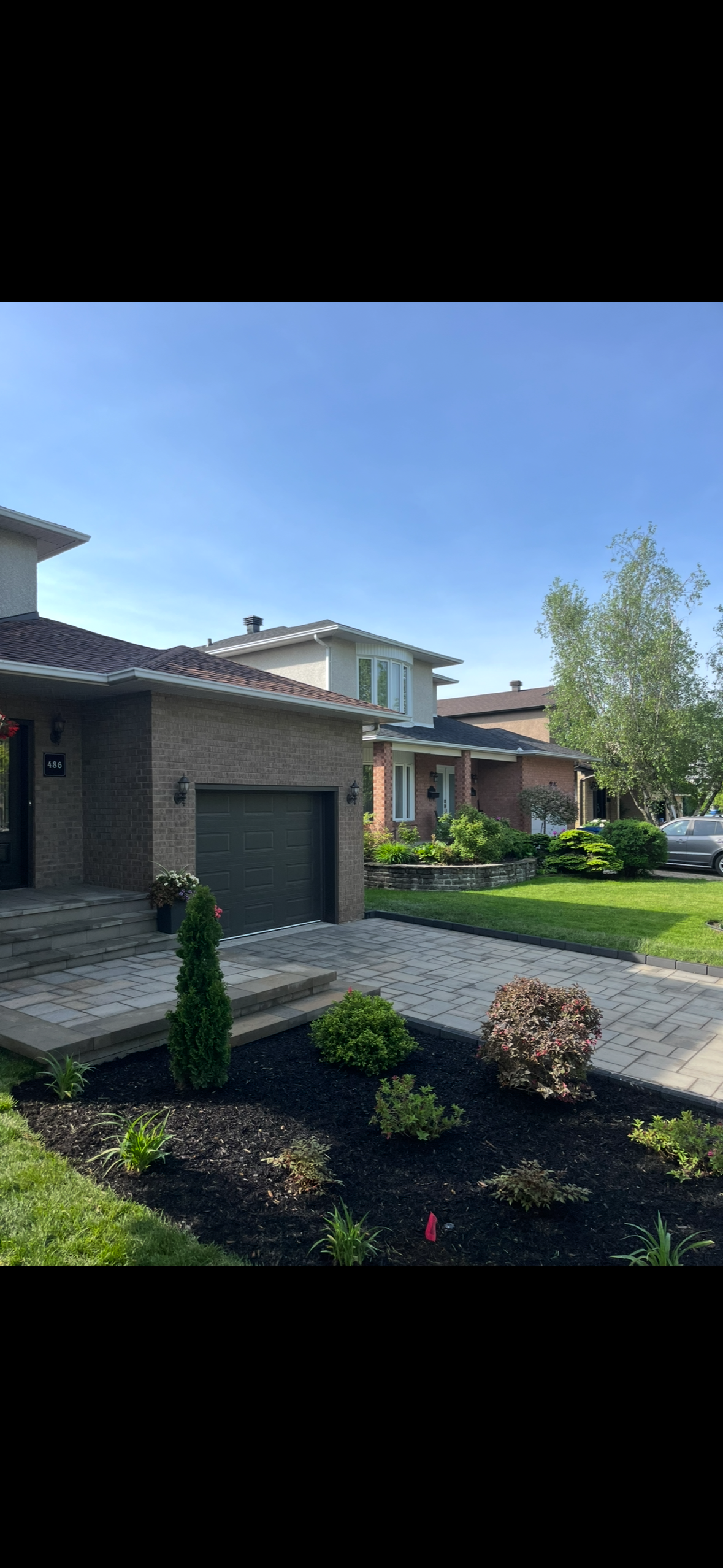 Une maison avec un garage et une allée devant.