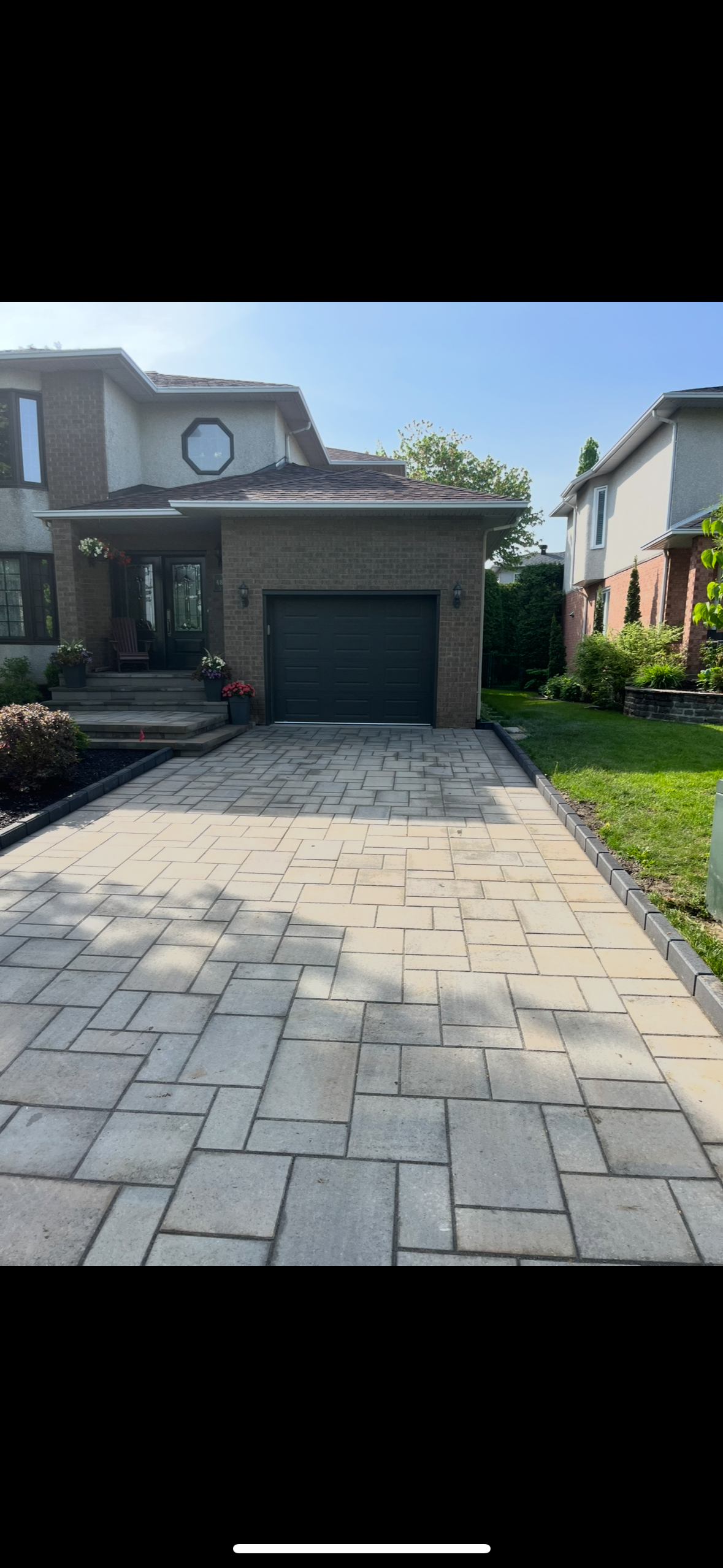 Une allée menant à une grande maison avec un garage.