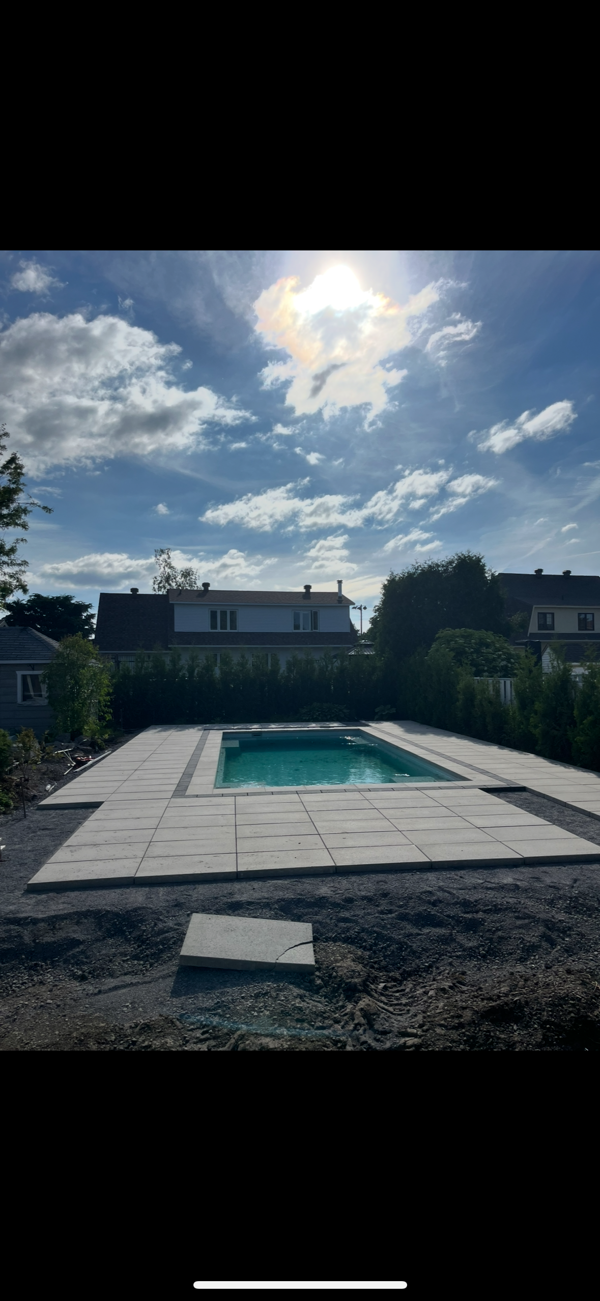 Une grande piscine dans une cour arrière avec une maison en arrière-plan.