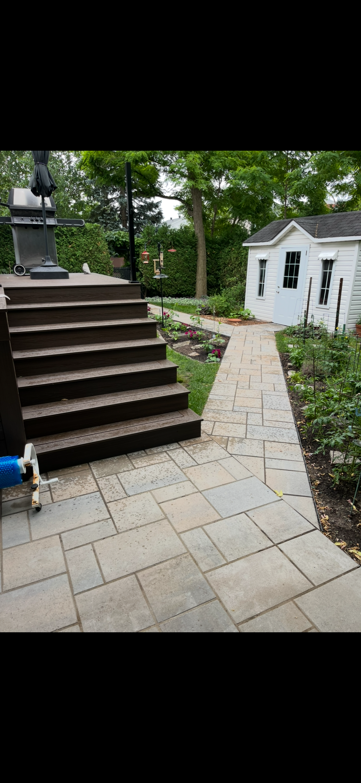 Un patio avec des escaliers et une passerelle menant à une maison.