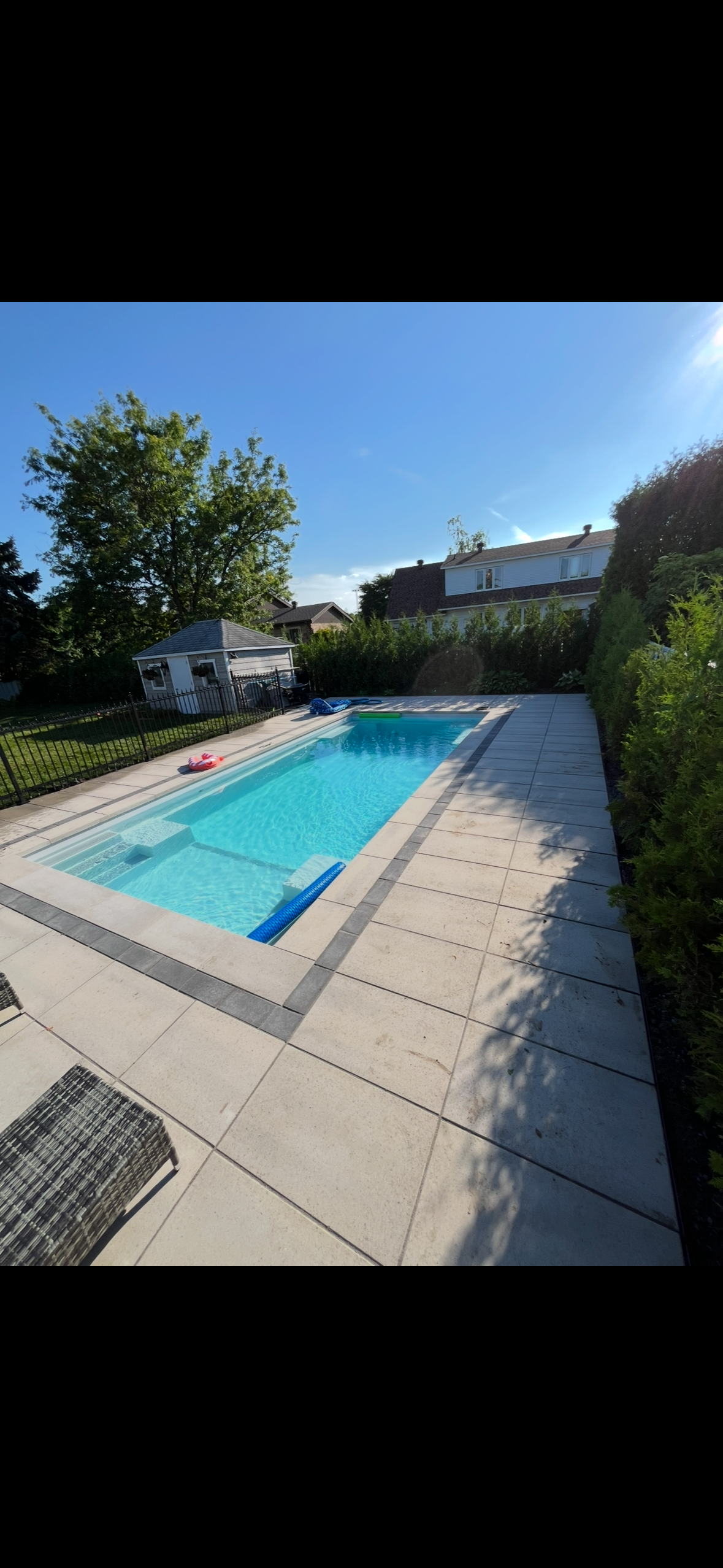 Une grande piscine dans l'arrière-cour d'une maison.