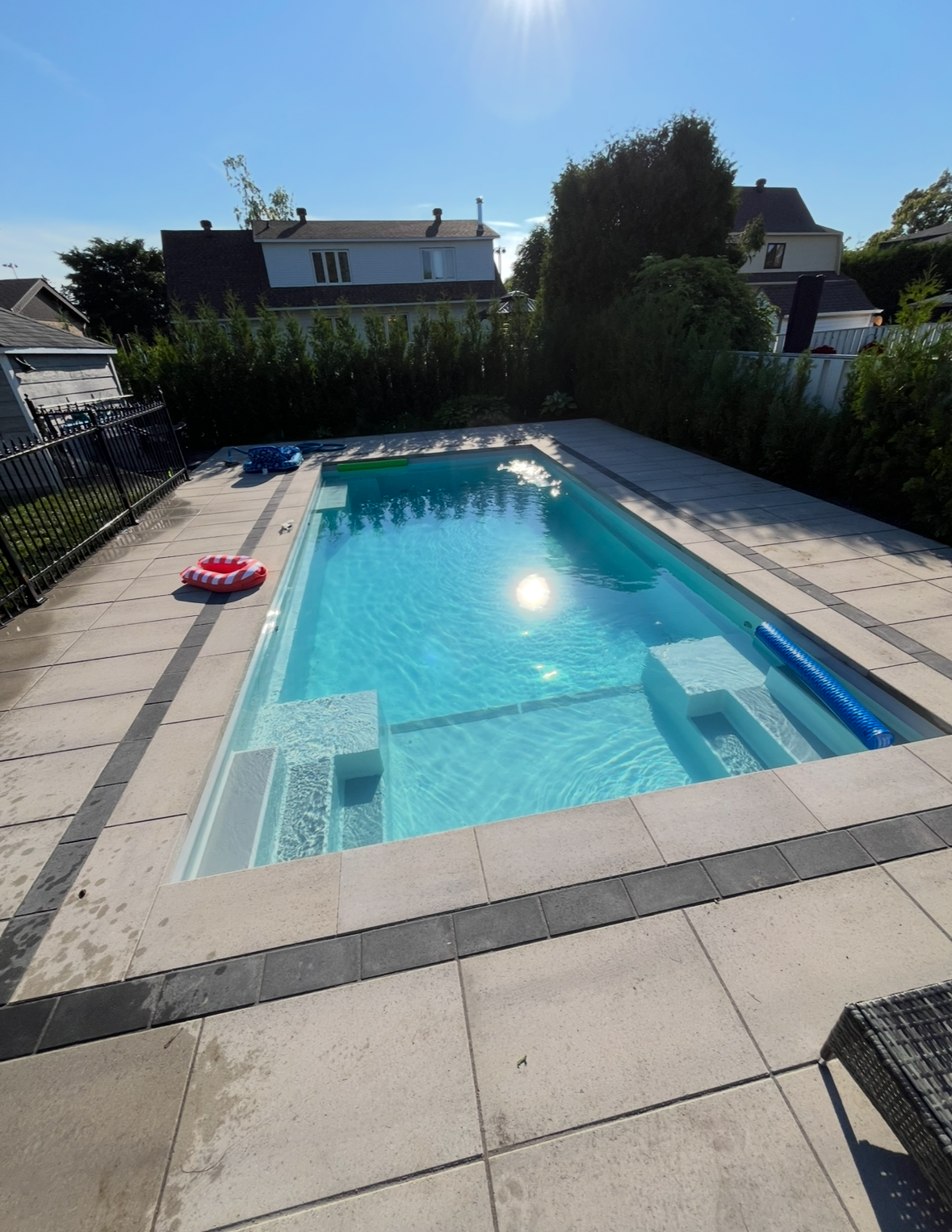 Une grande piscine dans une cour arrière entourée d'arbres