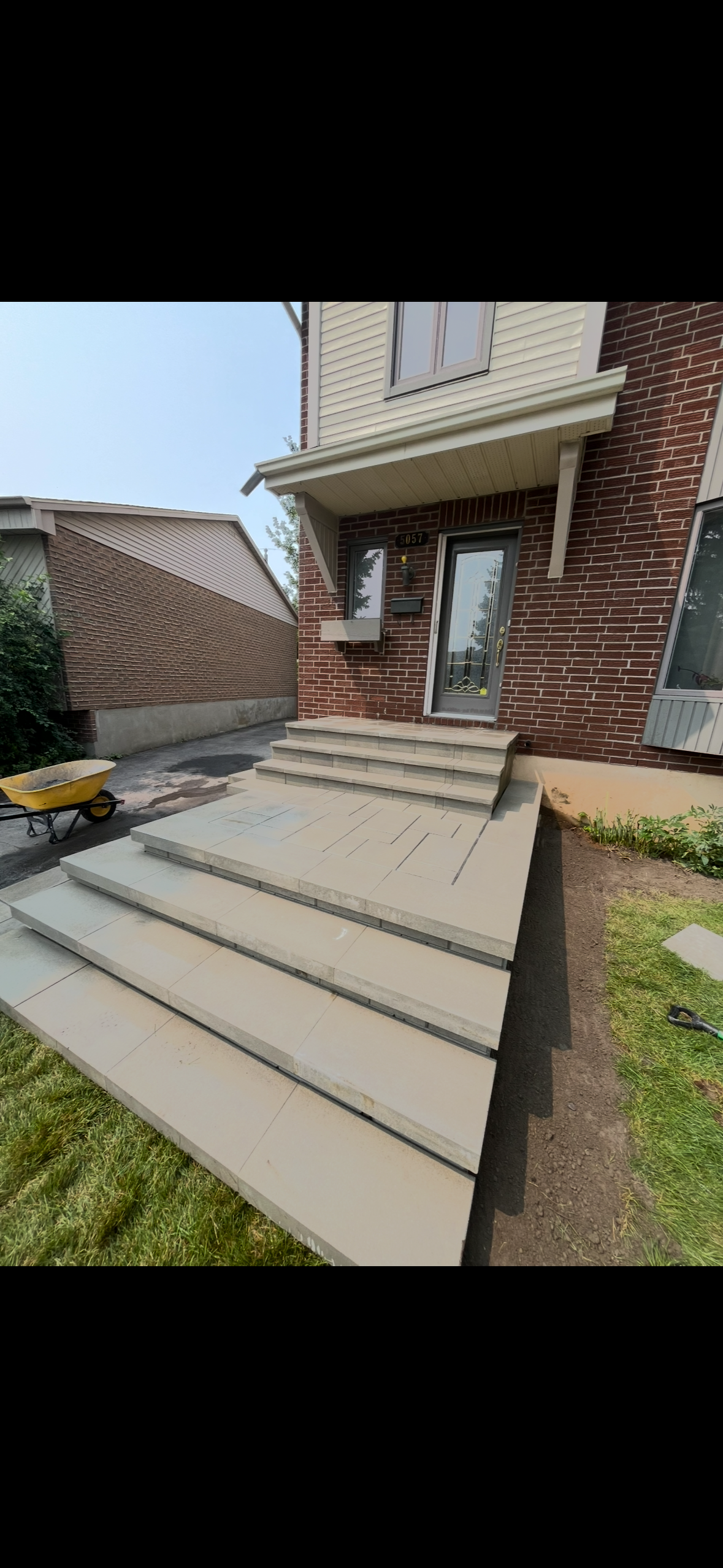 Un ensemble de marches en béton menant à une maison en briques.