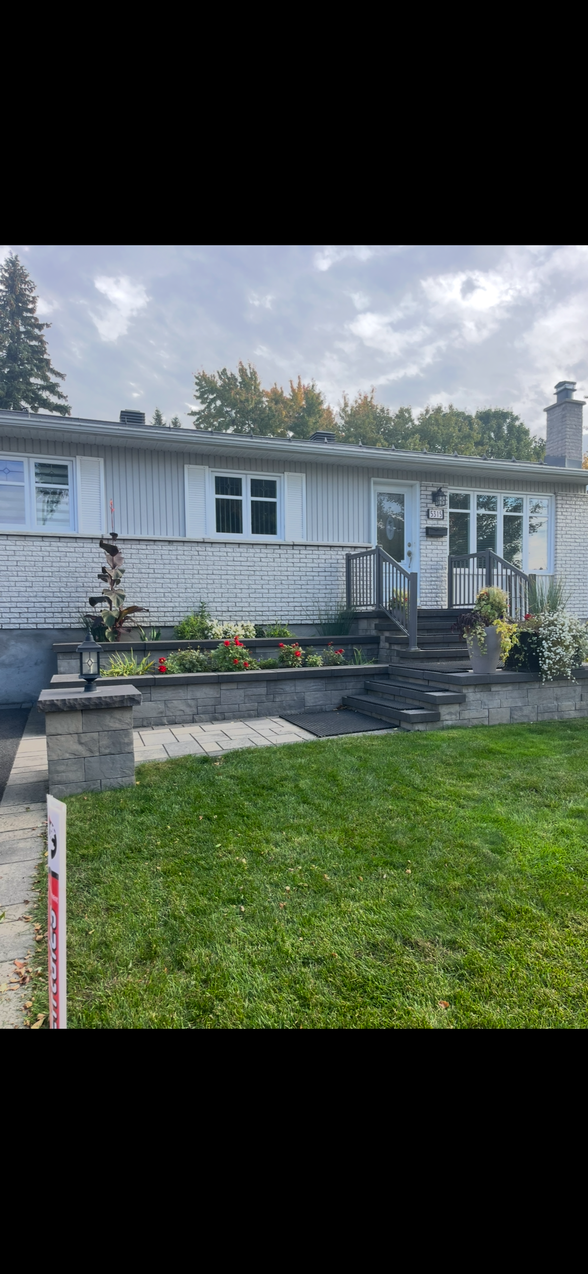 Une maison blanche avec une grande pelouse devant elle.